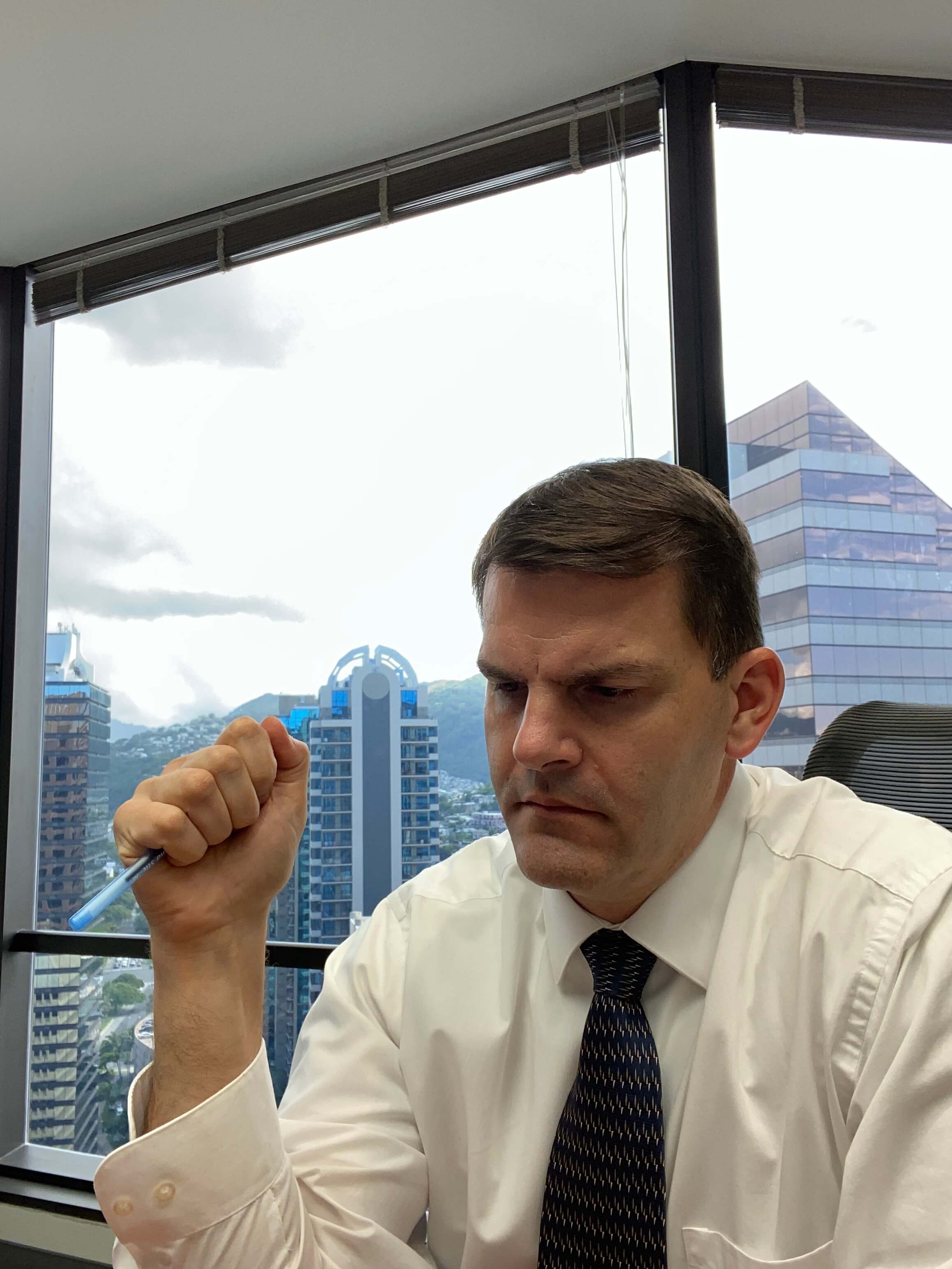 Jeff Liebenguth sits at his desk reading documentation for a sexual crimes defense.